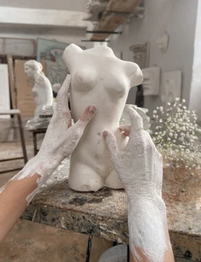 Création de site vitrine. Des mains sculptant un buste de femme